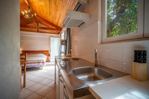 a kitchen with a sink and a window and a bed at Appartements tout équipés climatisés Piscine et Jardin in Marseille