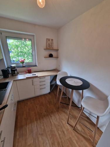 a kitchen with a table and two chairs and a window at EcoCube 142 - Balkon, 3Zimmer, Schlafsofa, Waschmaschine, Backofen, 6Pers in Meppen