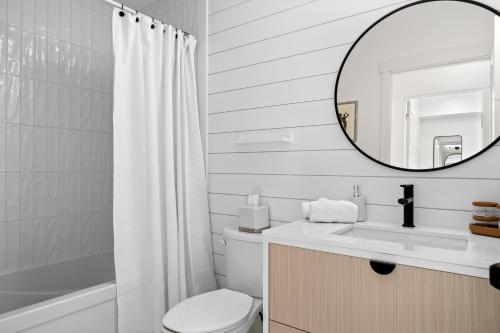 uma casa de banho branca com um lavatório e um espelho em The Belvedere:Front Street Flats em Belleville