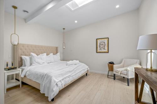 una camera bianca con un letto e una sedia di The Belvedere:Front Street Flats a Belleville