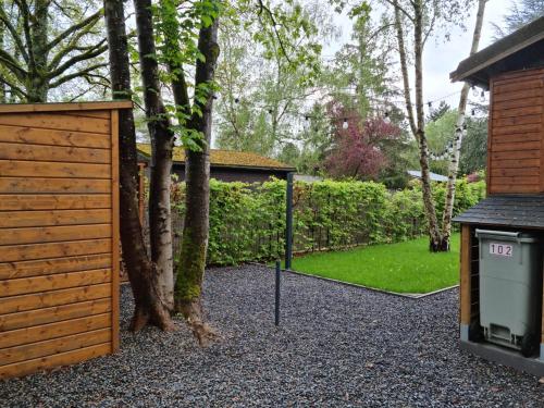 a gate and a tree in a yard at Le Cha'let Resteigne in Wellin