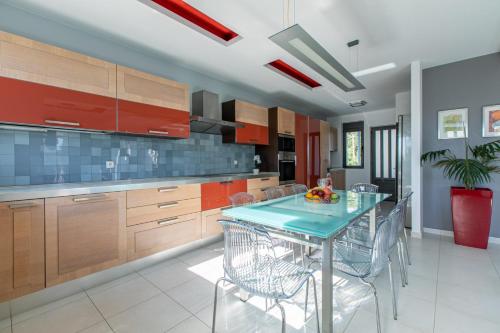 a kitchen with a table with chairs and cabinets at Crystal Waves lux villa-Homeleader in Chania Town