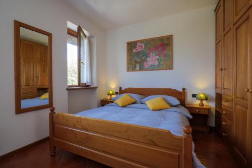 sypialnia z łóżkiem z niebieską pościelą i lustrem w obiekcie Villa Palma w mieście Colico