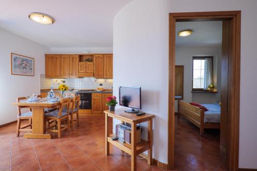 a kitchen and living room with a table and a television at Villa Palma in Colico
