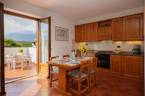 a kitchen with a table and a dining room with a view at Villa Palma in Colico