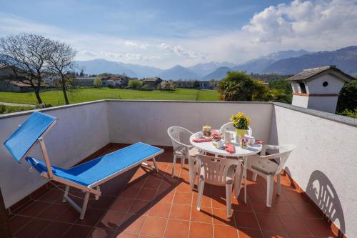 a patio with a table and chairs on a balcony at Villa Palma in Colico