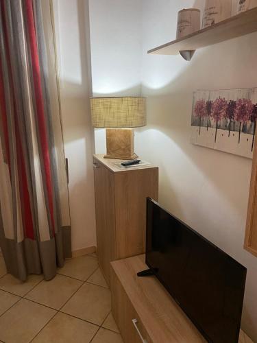 a living room with a flat screen tv and a lamp at Bilocale degli Innamorati in Terni