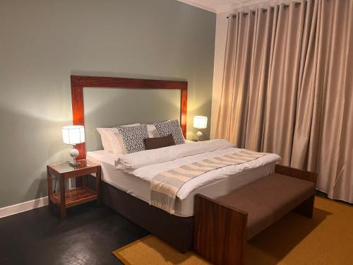 1 dormitorio con 1 cama grande y 2 lámparas en Andrella Home Arusha, en Arusha