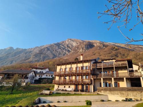 a large building with a mountain in the background at Apartments Pri Jakobu in Kobarid