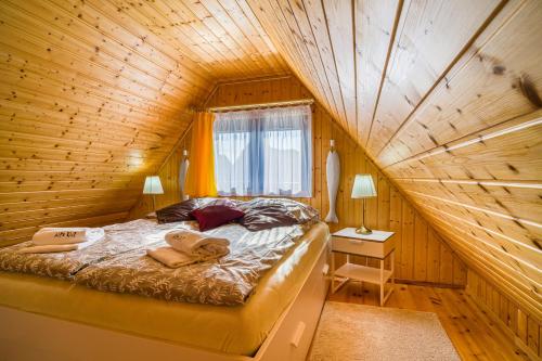 a bed in a room with a wooden ceiling at Domek przy morzu in Gąski