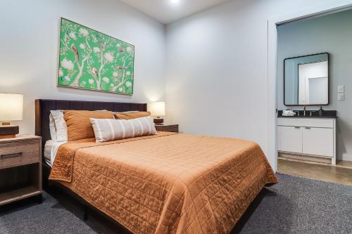 1 dormitorio con 1 cama grande y espejo en The Cypress Flats, en Lafayette