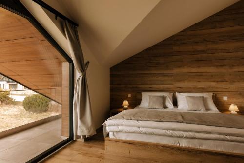 a bedroom with a bed and a large window at Villa Greystone in Nová Lesná