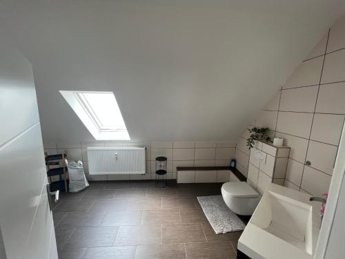 an attic bathroom with a toilet and a skylight at Mija in Nordenham