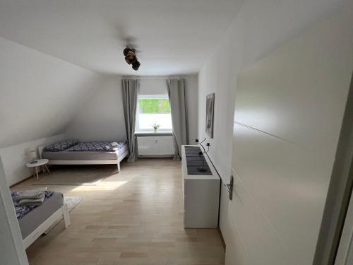 a small white room with a bed and a window at Mija in Nordenham
