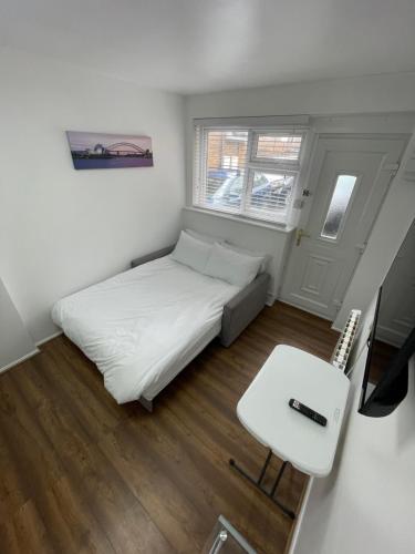 Dormitorio pequeño con cama y mesa en Fantastic Studio, Private bathroom and Mini Kitchen. en Thamesmead