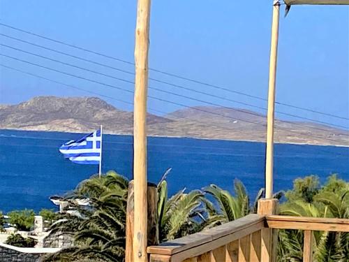 een balkon met een vlag en uitzicht op de oceaan bij Apsenti couples only in Agios Ioannis Mykonos