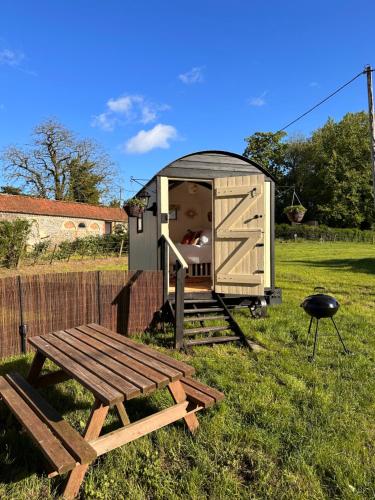 a wooden out house with a picnic table and a grill at The Hideaway in Fakenham