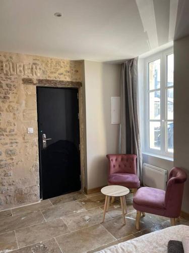 une chambre avec deux chaises, une porte et une table dans l'établissement Studio Ruben, à Bayeux