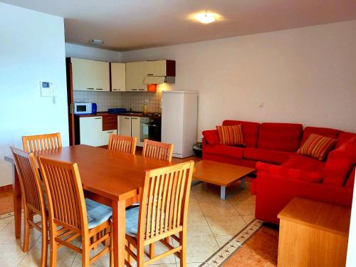 - un salon avec une table et un canapé rouge dans l'établissement Apartment Anna, à Novi Vinodolski