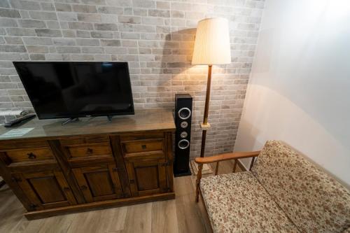 a living room with a flat screen tv and a chair at Casa Rural Casa Clemen in Villalba Baja