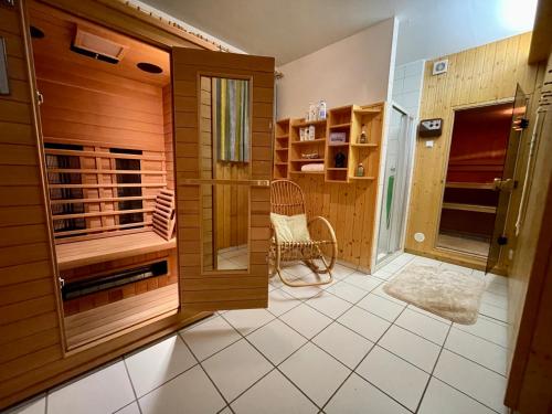 een kamer met een sauna met een bank en een stoel bij Landhaus Pölzl in Bodensdorf