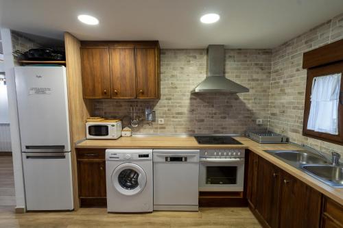 a kitchen with a white refrigerator and a washer at Casa Rural Casa Clemen in Villalba Baja