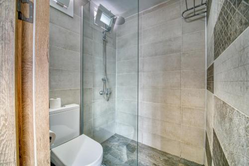 a bathroom with a toilet and a glass shower at The Port Of Kyrenia Hotel in Kérynia