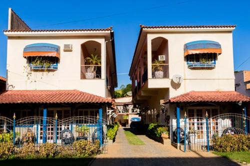 a two story building with blue gates in front of it at Pousada Oca Porã in Conservatória