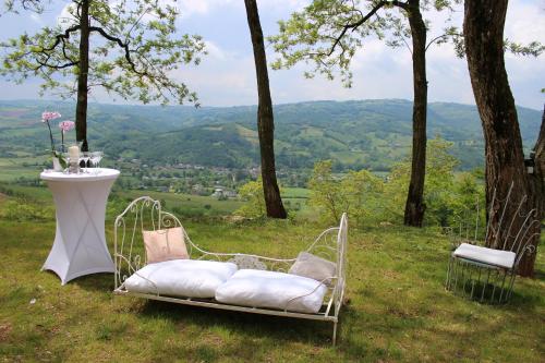 une chaise assise au sommet d'une colline avec une table dans l'établissement Domaine d'Exception, Maison d'artiste, à Clairvaux-dʼAveyron