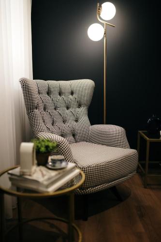 a living room with a chair and a table with a lamp at VIP apartments Bitola in Bitola