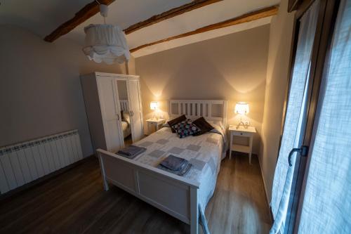 a bedroom with a large bed and two lamps at Casa Rural Casa Clemen in Villalba Baja