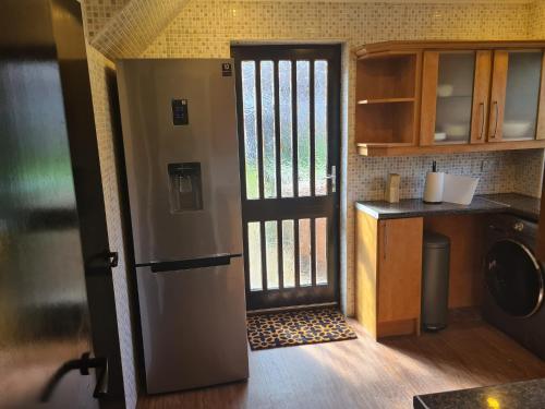 a kitchen with a door open to a kitchen with a counter at 3 BEDROOM HOUSE WITH FREE PARKING - Travel Host in Nitshill