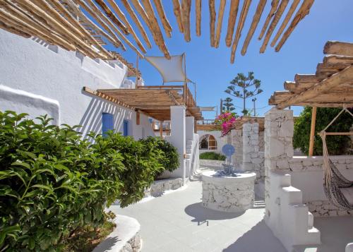 a courtyard with white buildings and a wooden ceiling at Apsenti couples only in Agios Ioannis Mykonos