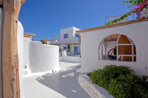 a white building with a door and a window at Apsenti couples only in Agios Ioannis Mykonos