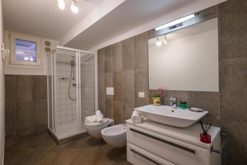uma casa de banho com um lavatório, um WC e um espelho. em Residence Girasole Casa Rossa A em Colico