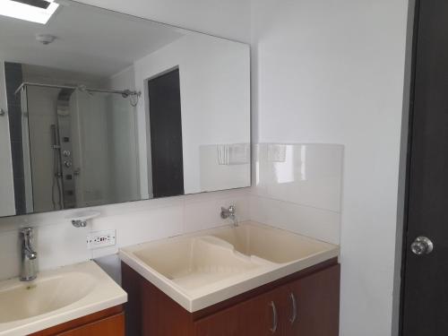 a bathroom with two sinks and a large mirror at Casa Colibrí Hospedaje Manizales a 2 min del Cable y 1 min Zona G in Manizales