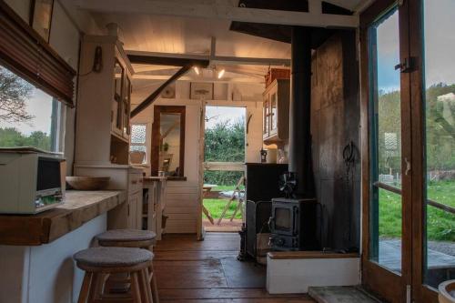a small kitchen with a stove in a tiny house at Shepherds Hut in enclosed field in Cardiff