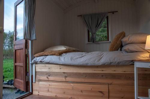 uma cama numa plataforma de madeira num quarto em Shepherds Hut in enclosed field em Cardiff
