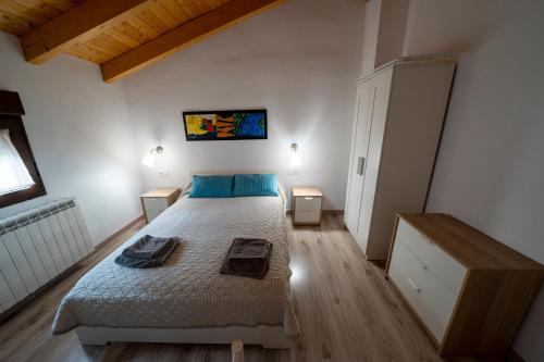 a bedroom with a bed with blue pillows on it at Casa Rural Casa Clemen in Villalba Baja
