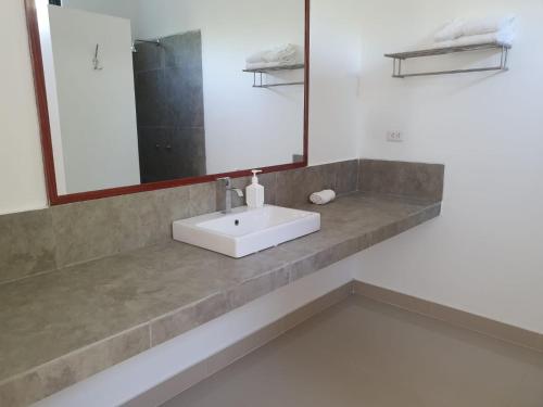 a bathroom with a white sink and a mirror at Las Hamacas in Canoas De Punta Sal