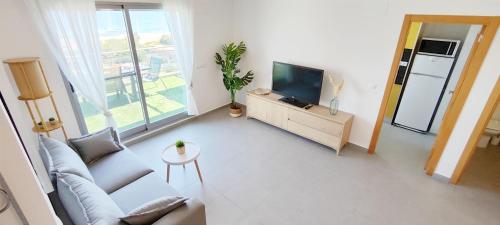a living room with a couch and a television at Apartamento Jardines de Deveses by DENIA COSTA in Denia