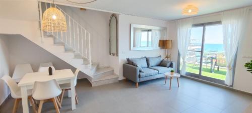 a living room with a staircase and a blue couch at Apartamento Jardines de Deveses by DENIA COSTA in Denia