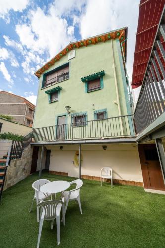 a building with a table and chairs in front of it at Casa Rural Casa Clemen in Villalba Baja