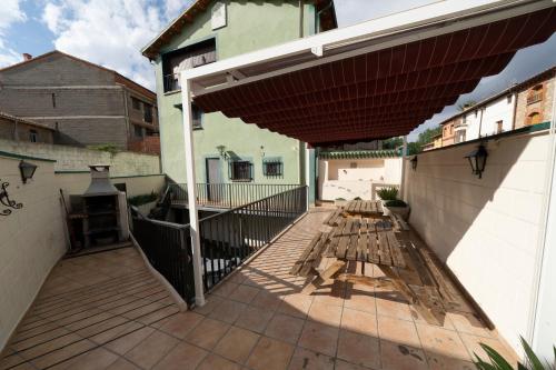 a patio with a wooden deck with a large umbrella at Casa Rural Casa Clemen in Villalba Baja
