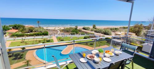 a table on a balcony with a view of the ocean at Apartamento Jardines de Deveses by DENIA COSTA in Denia