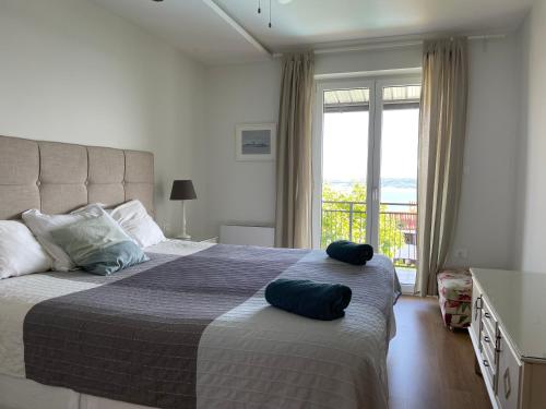 een slaapkamer met een groot bed met 2 kussens erop bij Villa Vilfanova- Apartments in Portorož