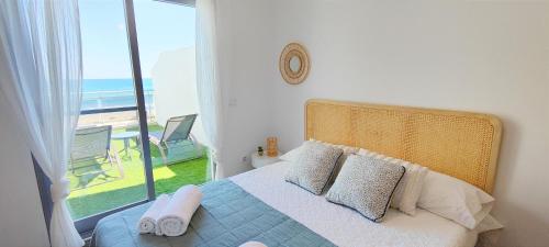 a bedroom with a bed with a view of the beach at Apartamento Jardines de Deveses by DENIA COSTA in Denia