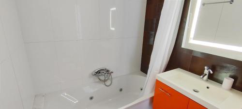 a bathroom with a white tub and a sink at Apartamento Jardines de Deveses by DENIA COSTA in Denia