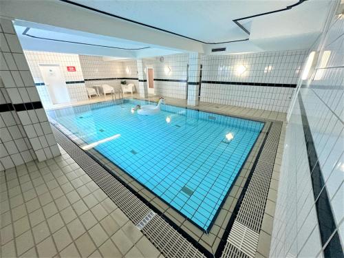 a large swimming pool with two people in it at COZY Apartment in Bavarian Forest +POOL +SAUNA +NETFLIX in Zwiesel