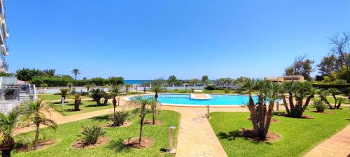 a resort with a swimming pool and palm trees at Apartamento Jardines de Deveses by DENIA COSTA in Denia
